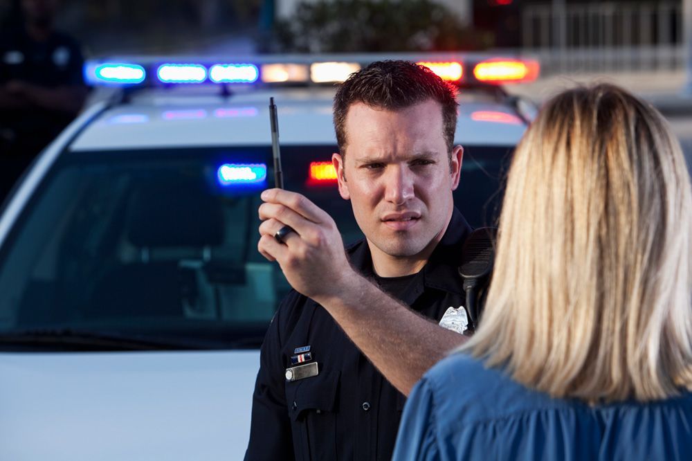 A police officer administers a roadside sobriety test.